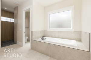 Full bath featuring toilet, a garden tub, and tile patterned flooring
