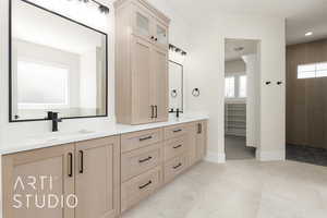Bathroom with double vanity, baseboards, and a closet