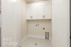 Laundry area featuring cabinet space, hookup for an electric dryer, washer hookup, baseboards, and light tile patterned floors
