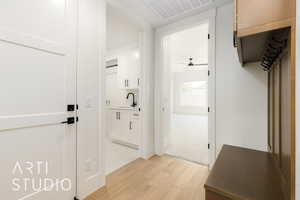 Hall featuring light wood-style flooring and a sink