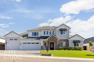 View of front of home with a front yard, driveway, board and batten siding, a garage, and brick siding