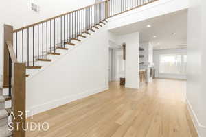 Unfurnished living room with light wood finished floors, stairs, baseboards, recessed lighting, and a tile fireplace