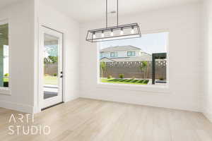 Unfurnished dining area featuring wood finished floors and plenty of natural light