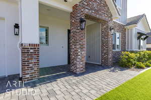 Property entrance featuring brick siding and stucco siding
