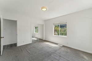 Unfurnished bedroom with carpet floors, baseboards, and a closet