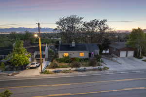 View of front of property with a mountain view, driveway, roof mounted solar panels, and a garage