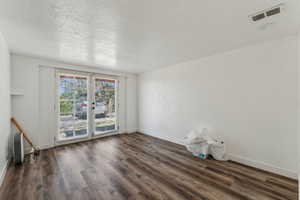 Unfurnished room with baseboards, visible vents, and wood finished floors