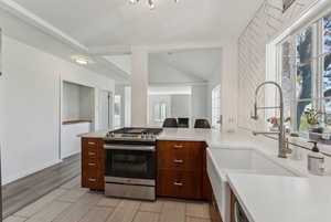 Kitchen featuring a sink, a healthy amount of sunlight, gas stove, and light countertops