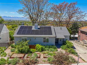 Exterior space with brick siding, solar panels, and a chimney