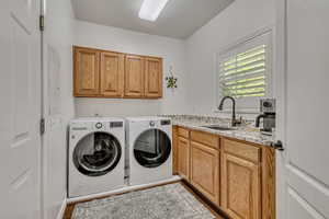 Clothes washing area featuring cabinet space, independent washer and dryer, a textured ceiling, and wood finished floors
