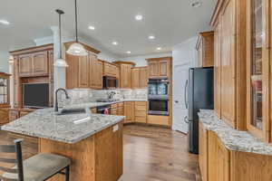 Kitchen featuring stainless steel appliances, a sink, ornamental molding, a peninsula, and tasteful backsplash