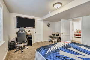 Bedroom with carpet floors, a textured ceiling, and baseboards