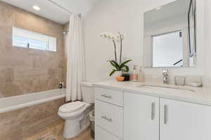 Bathroom with toilet, tiled shower / bath, vanity, and recessed lighting
