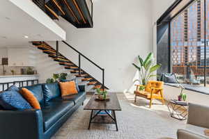 Living area with stairs, recessed lighting, and wood finished floors