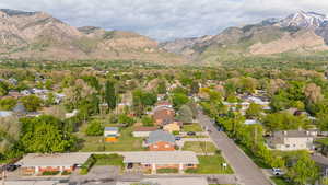 Aerial view of property and surrounding area with mountains and nearby suburban area