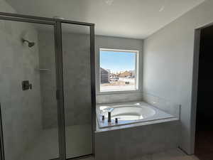 Bathroom featuring a stall shower, tile patterned floors, a bath, and a textured ceiling