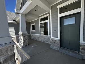 Property entrance featuring a porch and stone siding