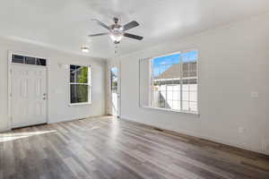 Entrance foyer featuring crown molding, a ceiling fan, wood finished floors, and baseboards