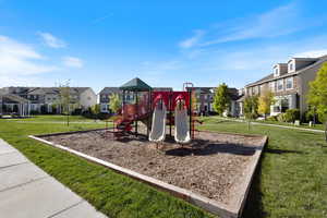 Community play area with a residential view and a lawn