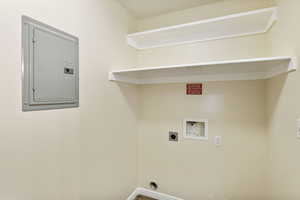 Clothes washing area with electric panel, washer hookup, hookup for an electric dryer, and baseboards