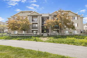 View of building exterior with a fenced front yard and stairway