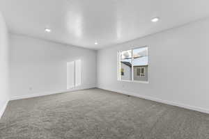 Unfurnished room featuring carpet flooring, baseboards, and recessed lighting