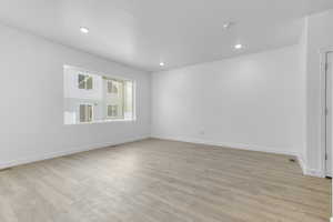 Unfurnished room with light wood-type flooring, baseboards, and recessed lighting