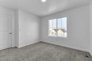 Carpeted spare room with baseboards