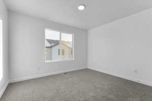 Carpeted empty room featuring baseboards