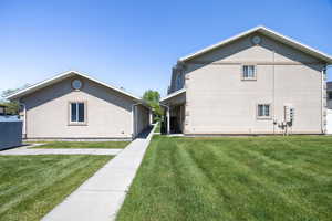 Row End Unit - Side of house with a yard and stucco siding