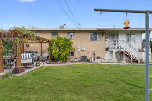 Rear view of property featuring brick siding, a yard, a pergola, and a patio area