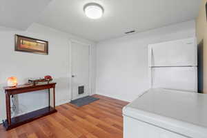 Entrance through garage featuring light wood-style floors and baseboards