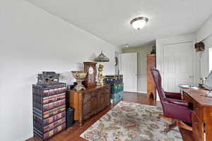 Office area with dark wood-style flooring and a textured ceiling