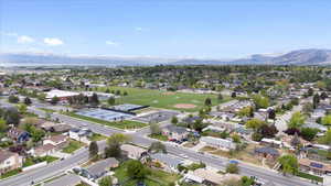 Aerial view of property and surrounding area with a mountain backdrop and nearby suburban area