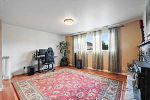 Office area featuring wood finished floors, radiator, and baseboards