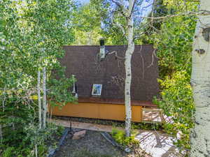 View of side of property with roof with shingles
