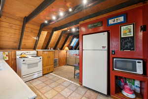 Kitchen with tile countertops, white appliances, and wood ceiling