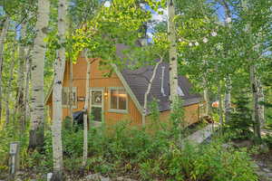View of side of home featuring roof with shingles