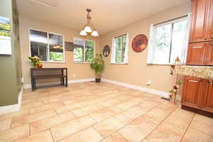 Dining room featuring plenty of natural light, baseboards, and light tile patterned flooring
