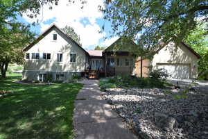 View of front of home with a front yard, a garage, and driveway