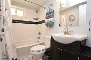 Bathroom featuring toilet, vanity, and shower / tub combo with curtain
