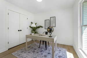 Office area with light wood-style floors and baseboards