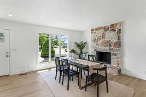 Dining space featuring baseboards, light wood finished floors, a fireplace, and recessed lighting