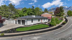 Ranch-style home featuring a mountain view, a garage, fence, and brick siding