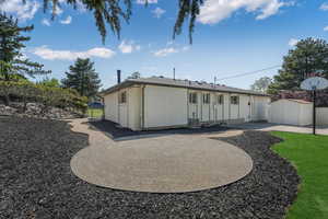 Rear view of house with a patio, fence, brick siding, an outdoor structure, and cooling unit