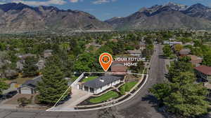 Aerial view of residential area featuring property boundaries highlighted and a mountainous background