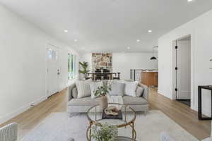 Living area with light wood-style floors, recessed lighting, and baseboards