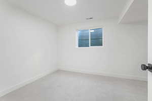 Unfurnished room featuring baseboards and light colored carpet