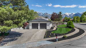 View of front of property with a mountain view, driveway, an attached garage, and brick siding