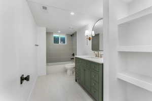 Bathroom with tub / shower combination, toilet, vanity, baseboards, and recessed lighting